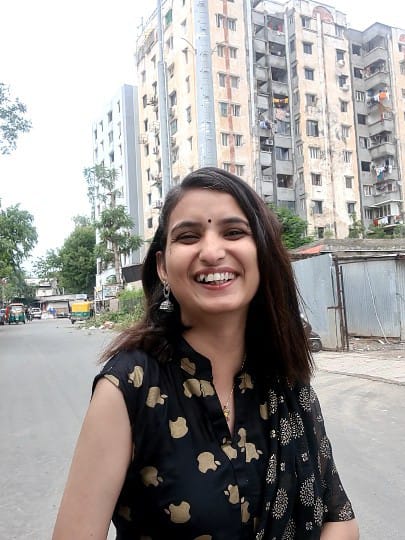 Casual day — black floral dress, candid smile on a city street