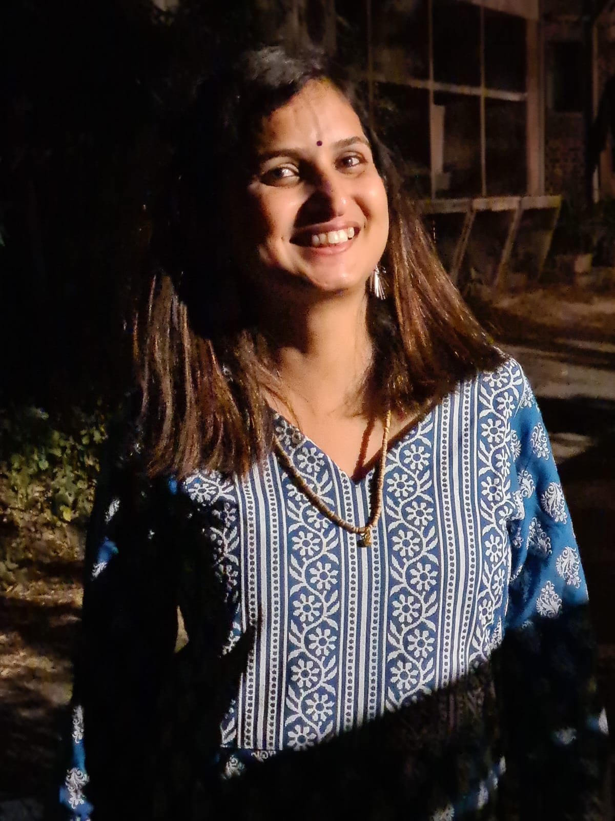 Ethnic casual — blue block-print kurta, warm smile, night portrait